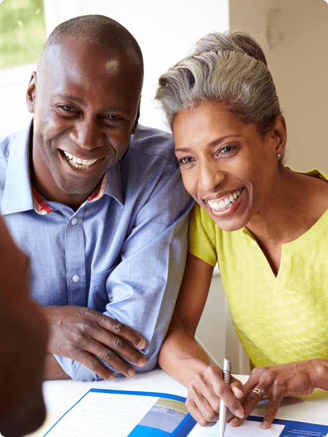 A smiling happy couple applying for a loan